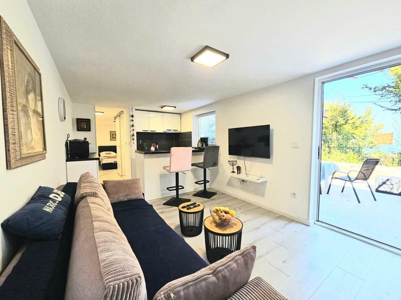 Wohnbereich mit Sofa und Ausgang zur Terrasse in Njivice