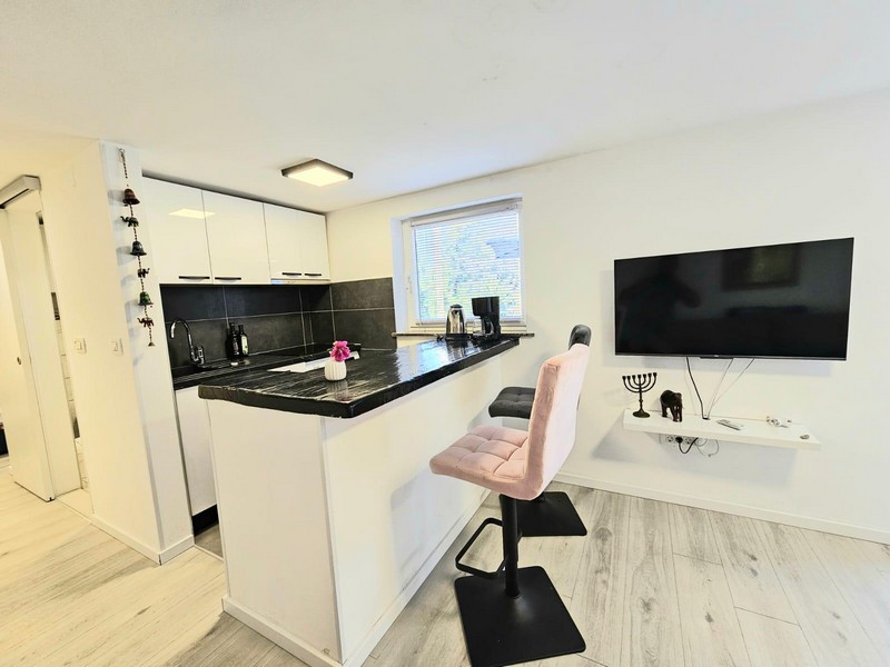 Küche mit Theke und Fernseher in der Wohnung in Njivice