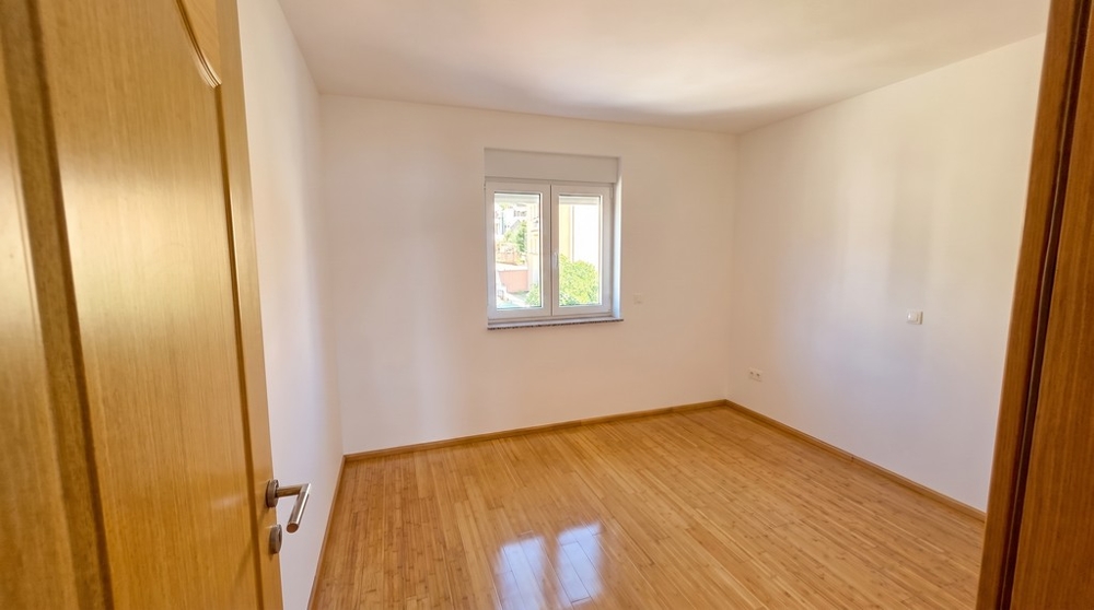 Schlafzimmer mit Parkettboden und Fenster