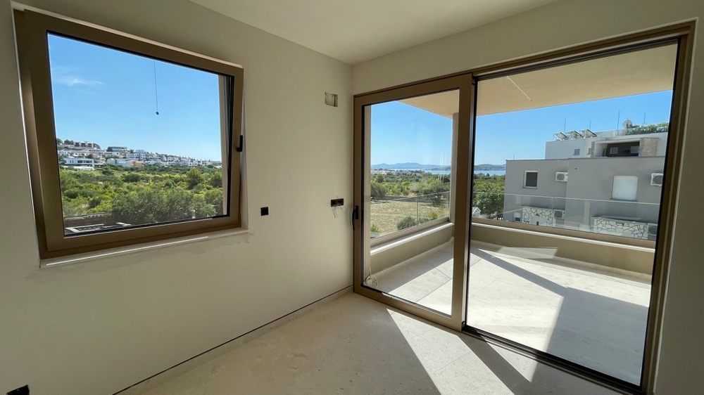 Wohnbereich mit Glasschiebetür zur Terrasse und Meerblick