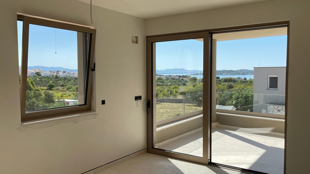 Wohnzimmer mit großer Fensterfront und Meerblick der Wohnung A4106