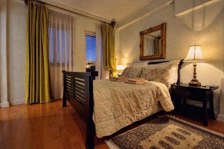 Schlafzimmer mit Doppelbett und hohen Fenstern