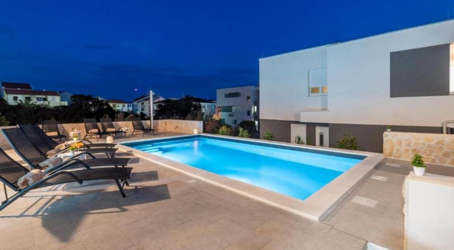 Pool der Wohnanlage in Novalja am Abend