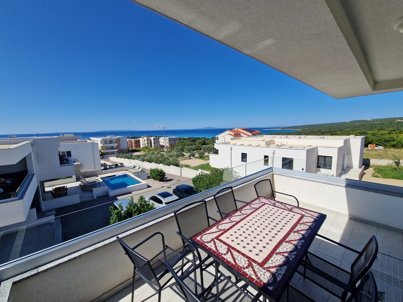 Terrasse mit Blick auf Meer und Wohnanlage