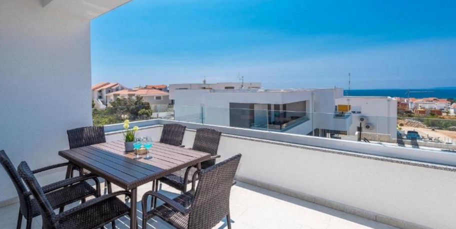 Überdachte Terrasse mit Esstisch und Blick über Novalja