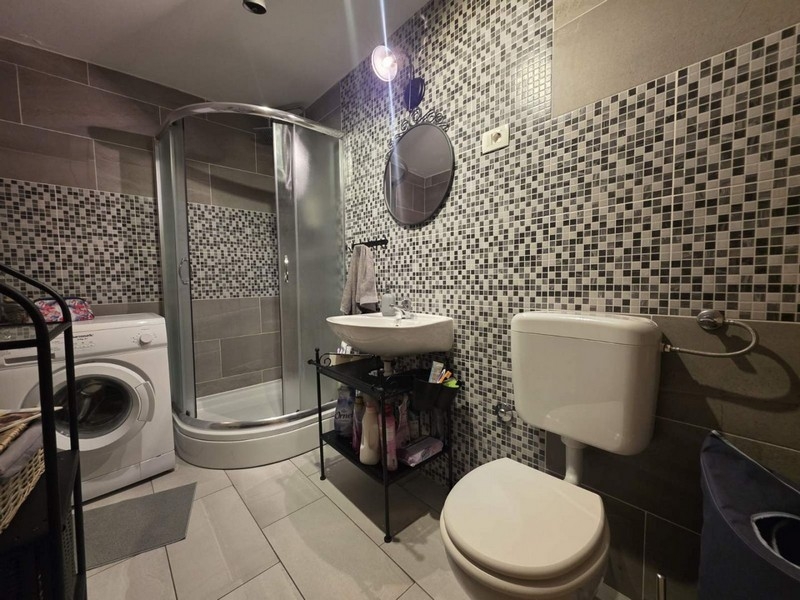 Badezimmer mit Dusche und Waschmaschine