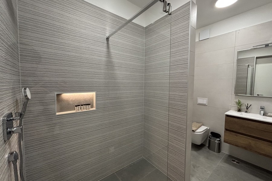 Badezimmer mit begehbarer Dusche und Waschtisch in Trogir