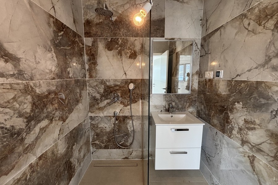 Badezimmer mit Dusche und Marmorfliesen