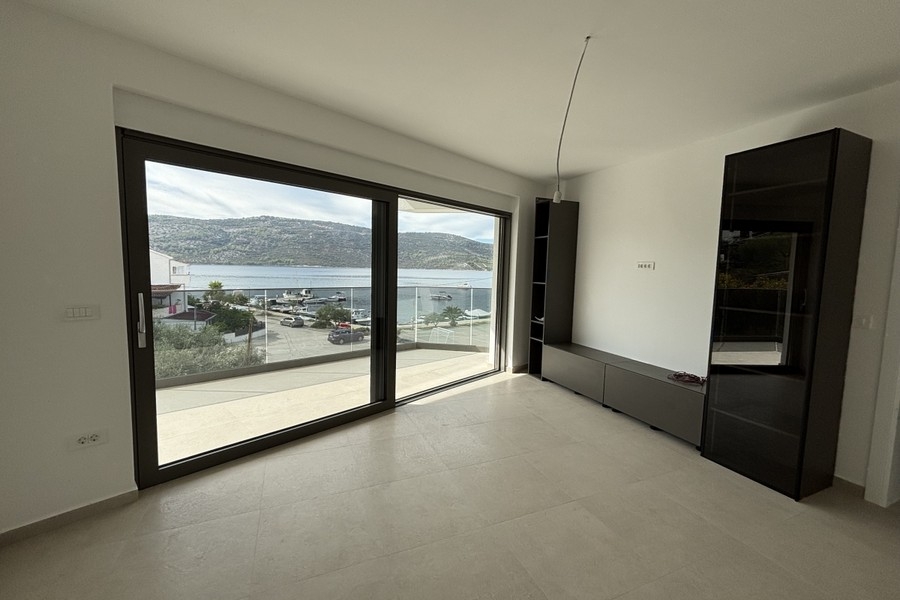 Wohnzimmer mit bodentiefer Fensterfront und Meerblick