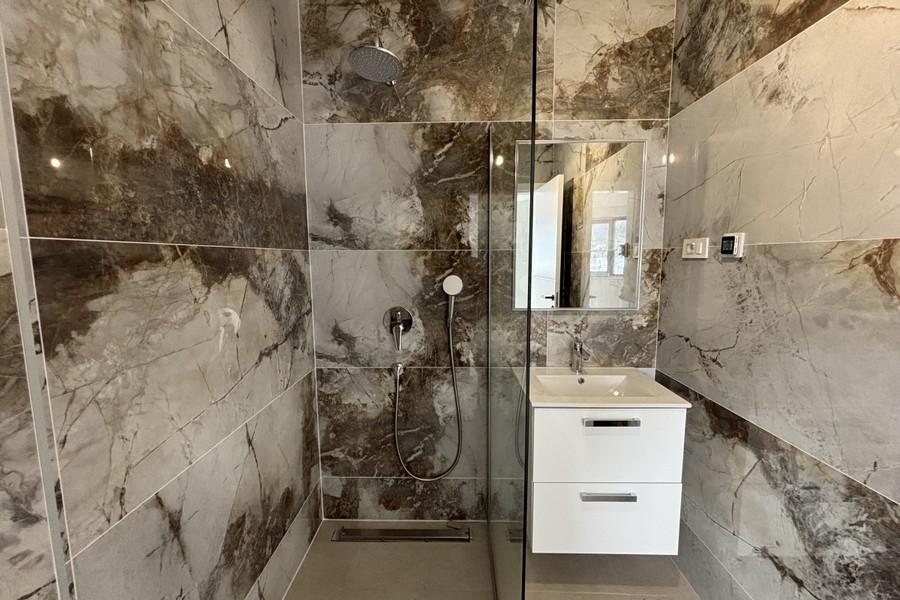 Weiteres Badezimmer mit hellen Natursteinfliesen