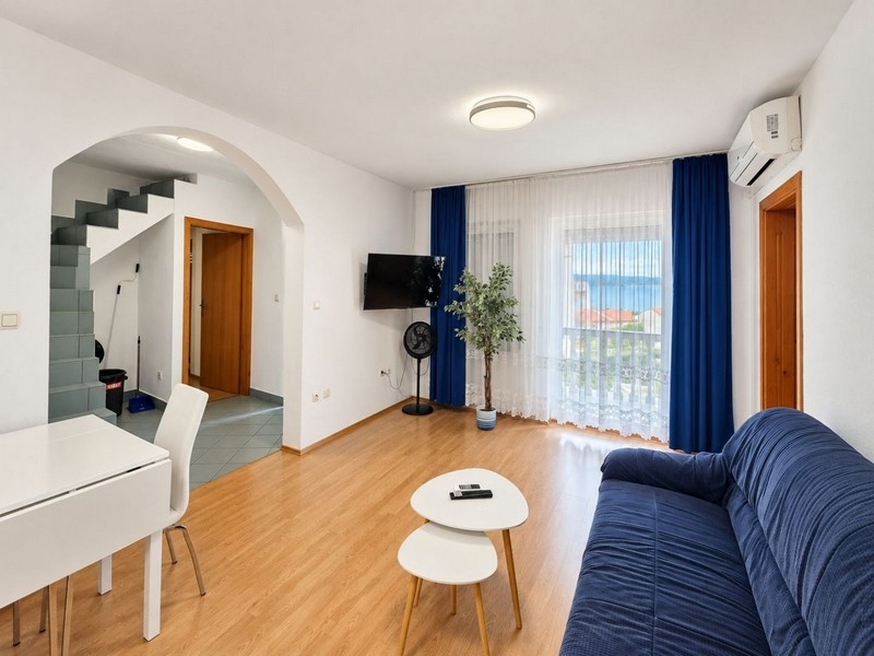 Wohnraum mit Sofa, Klimaanlage und Fenstertür