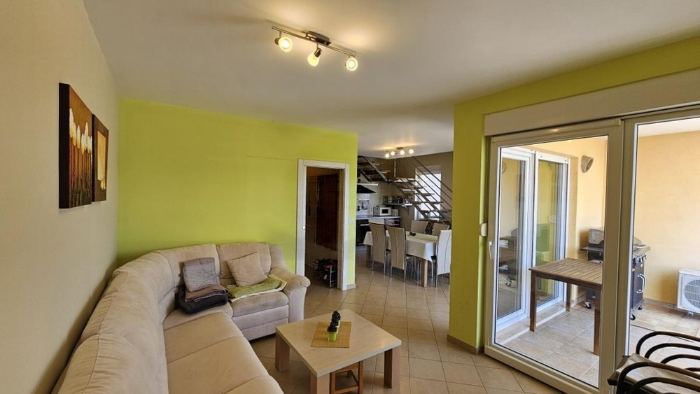 Wohnraum mit Sofa und Zugang zum Balkon