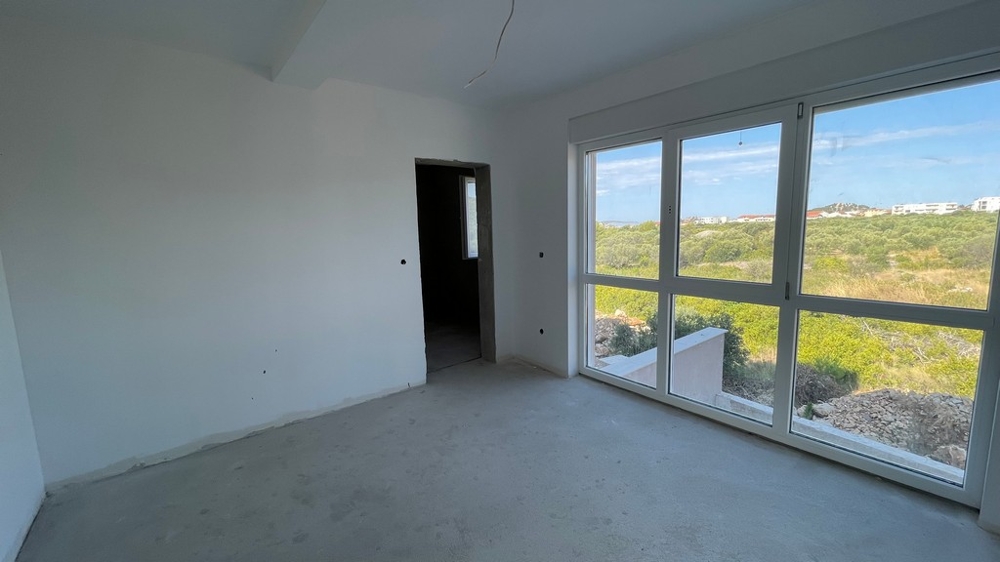 Zimmer mit großer Fensterfront und Blick ins Grüne