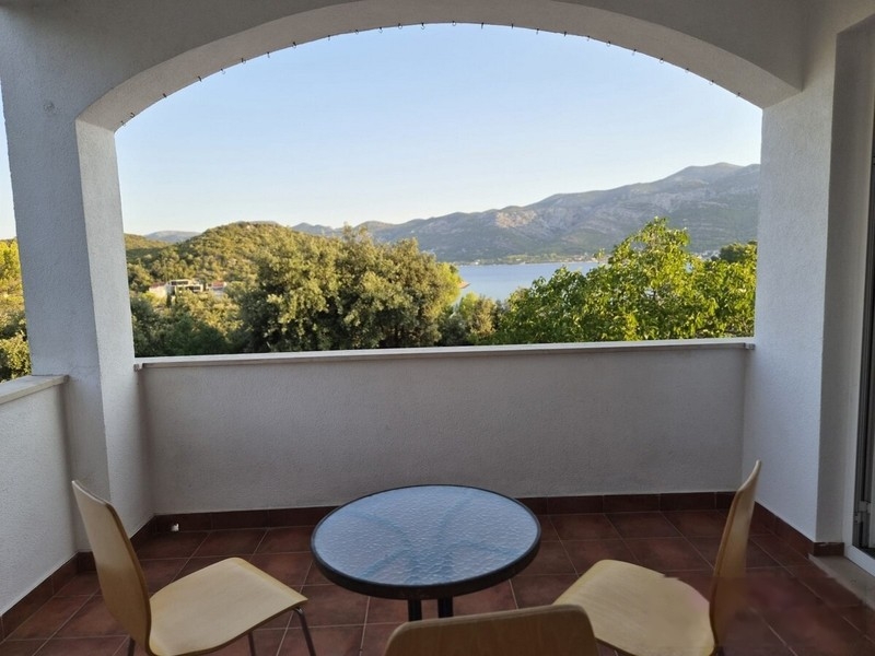 Loggia mit Rundbogen, Tisch und Stühlen