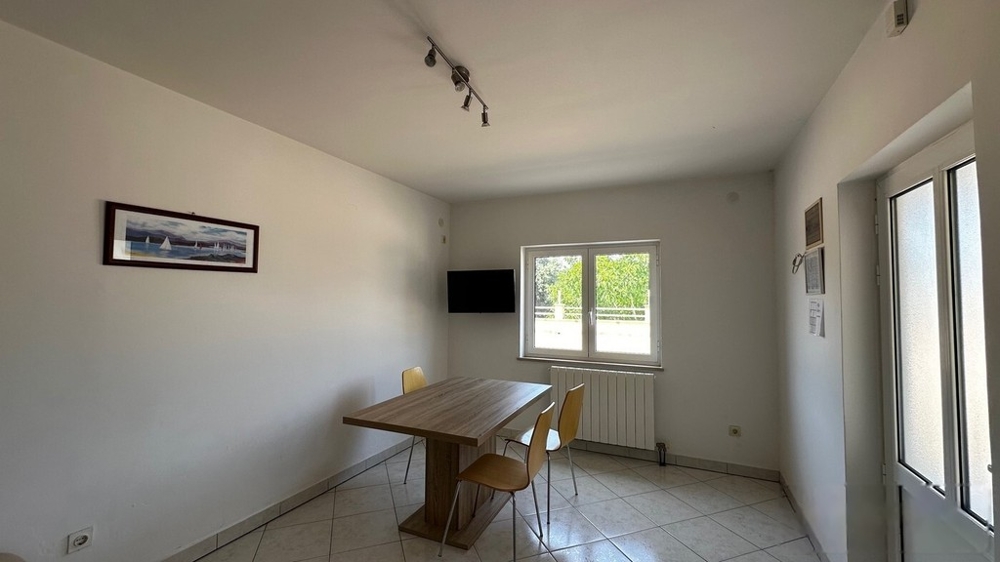 Wohnzimmer mit Esstisch und Fenster zur Terrasse