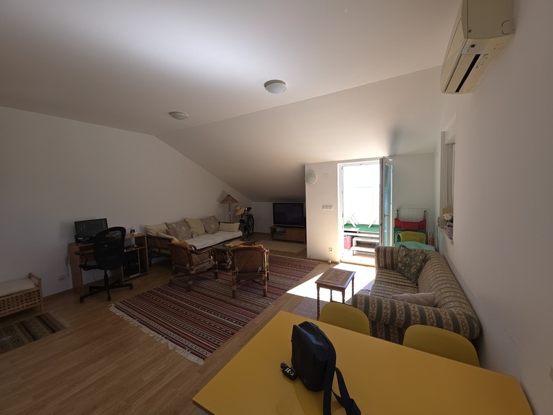 Wohnzimmer mit Sitzecke und Esstisch unter der Dachschräge