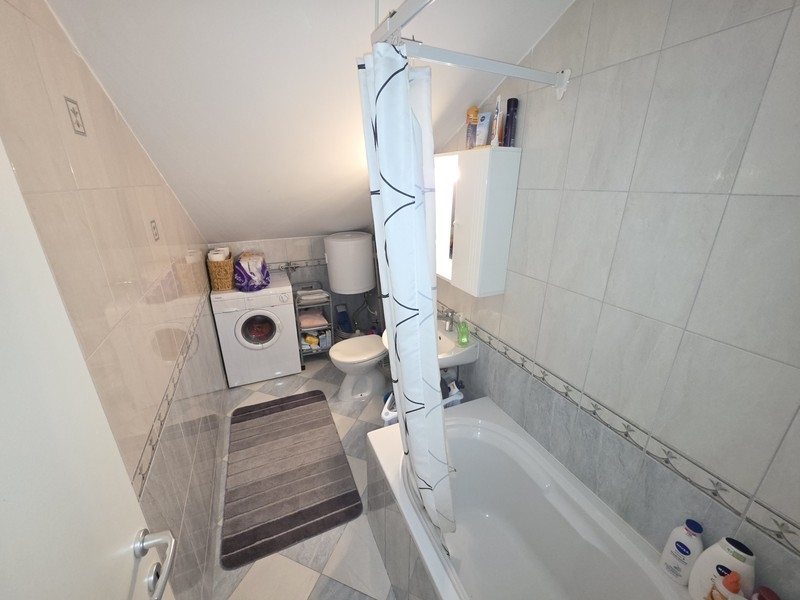 Badezimmer mit Badewanne und Waschmaschine