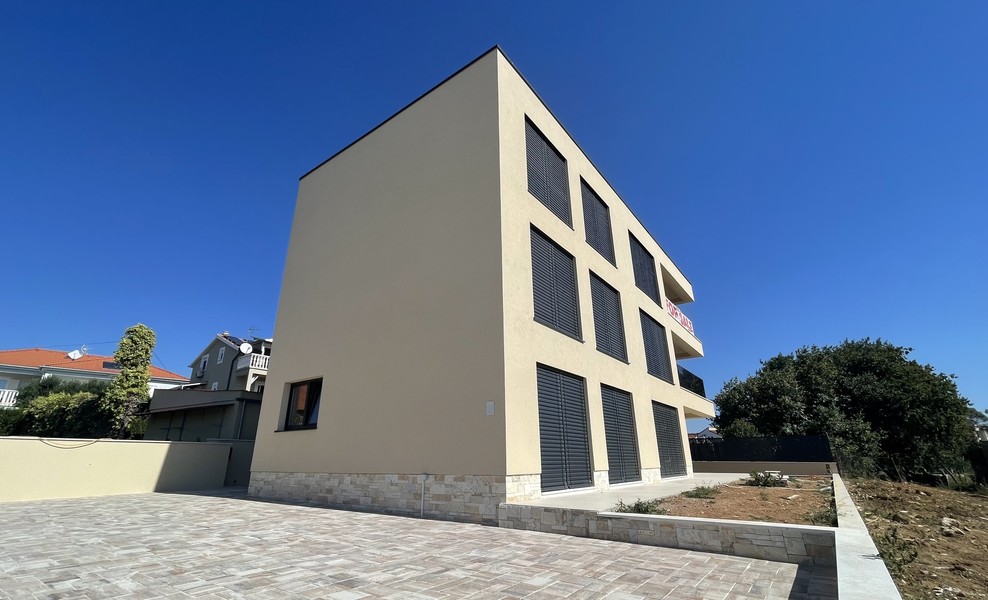 Seitenansicht des Neubaus mit gepflastertem Hof