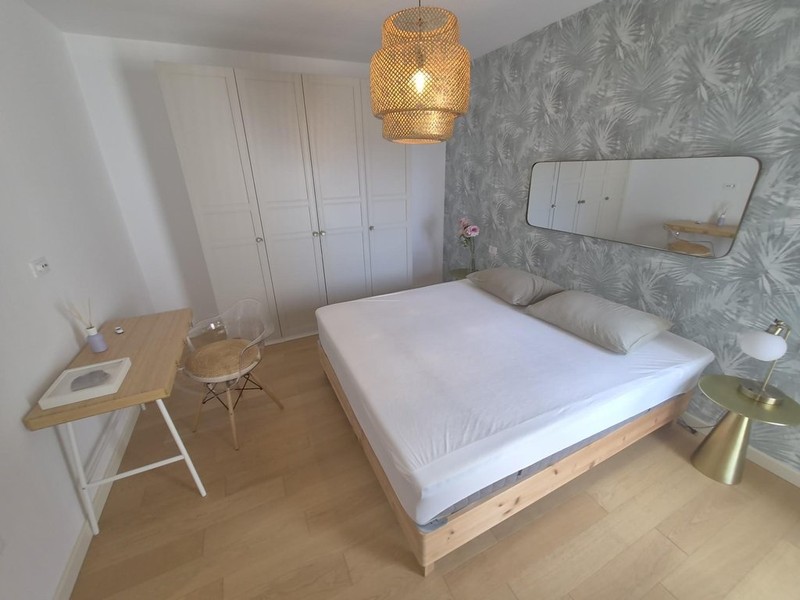 Doppelbett vor gemusterter Tapete