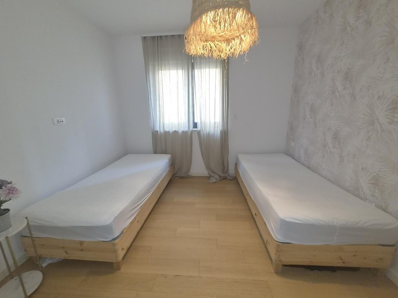 Zweites Schlafzimmer mit Vorhängen am Fenster
