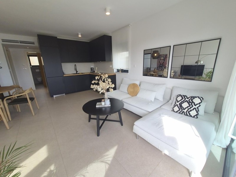 Wohnzimmer mit weißem Sofa und Küchenzeile