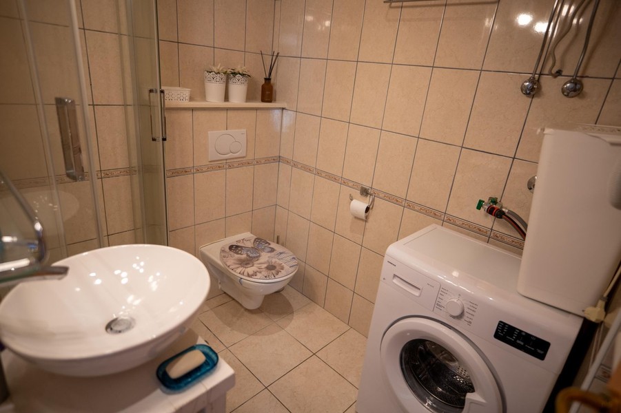 Badezimmer mit Dusche und Waschmaschine