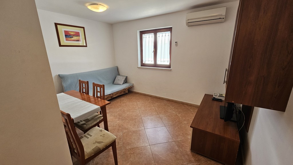 Wohnzimmer der zweiten Einheit mit Sofa und Esstisch