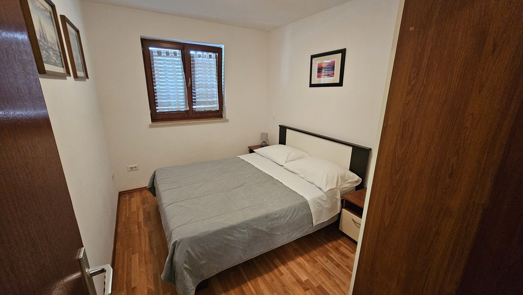Zweites Schlafzimmer mit Doppelbett und Holzboden