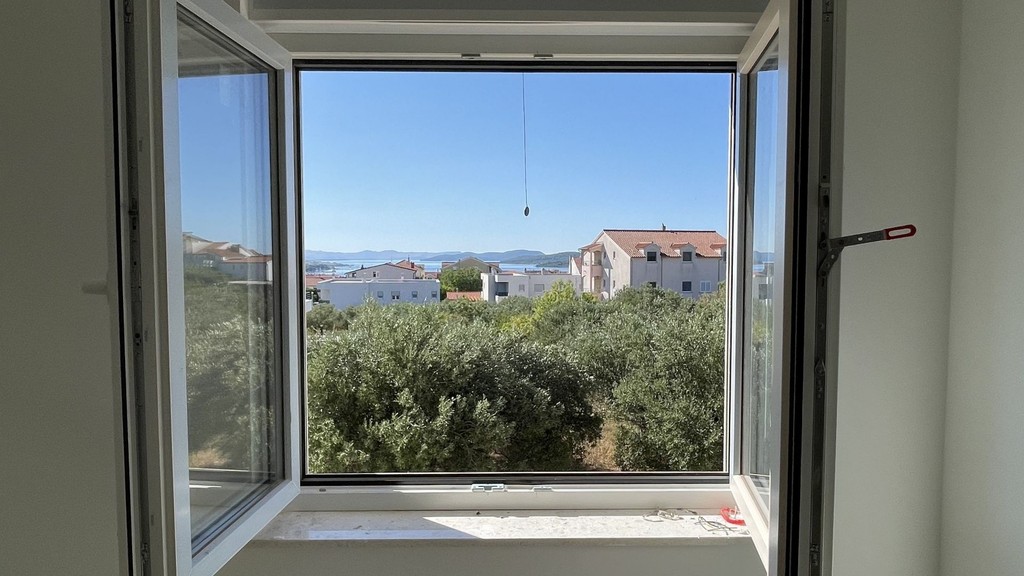 Ausblick aus dem geöffneten Fenster auf das Meer