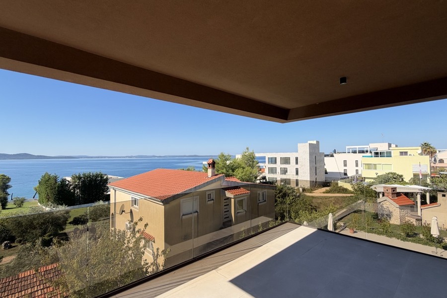 Balkon mit Glasgeländer und Blick über die Bucht