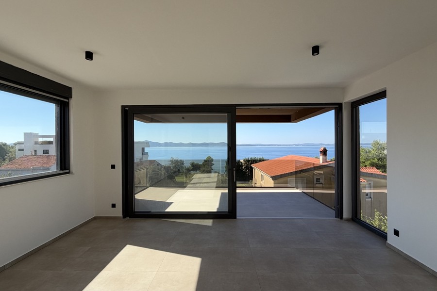 Wohnbereich mit großen Fensterfronten zum Balkon