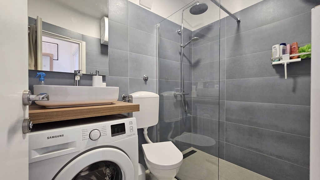 Badezimmer mit Dusche und Waschmaschine
