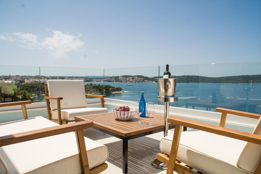 Terrasse mit Loungemöbeln und Blick auf die Bucht