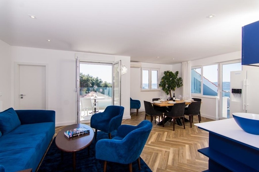 Wohnzimmer mit Sofaecke und Fenstern zum Meer