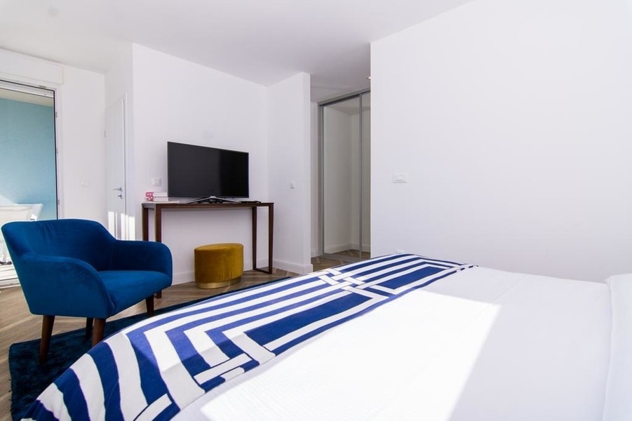 Schlafzimmer mit Sessel und Fernseher
