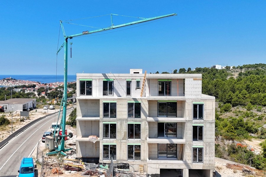 Baustelle mit Kran, links die Altstadt am Meer