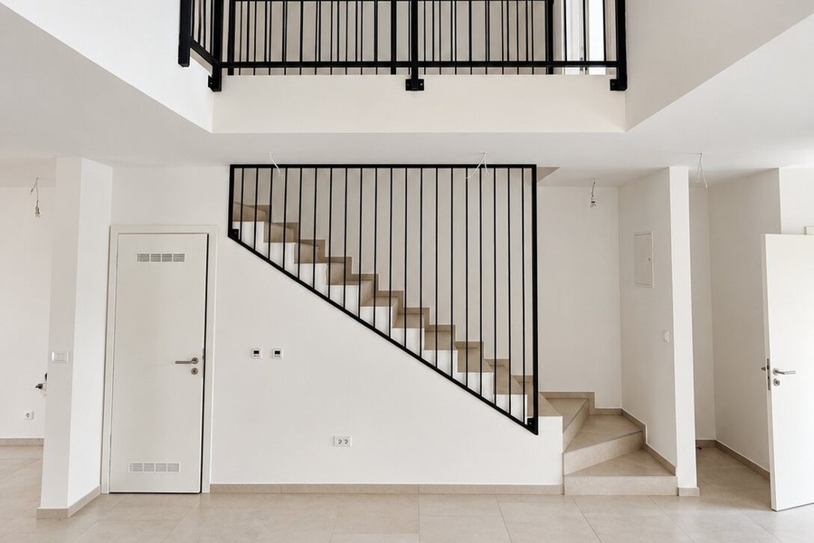 Treppe mit schwarzem Metallgeländer