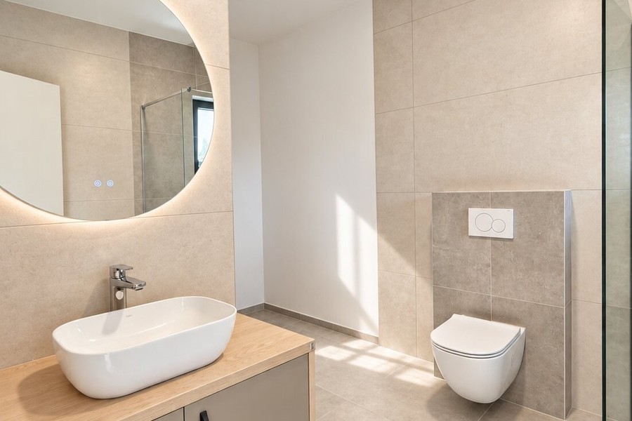 Badezimmer mit beleuchtetem Rundspiegel