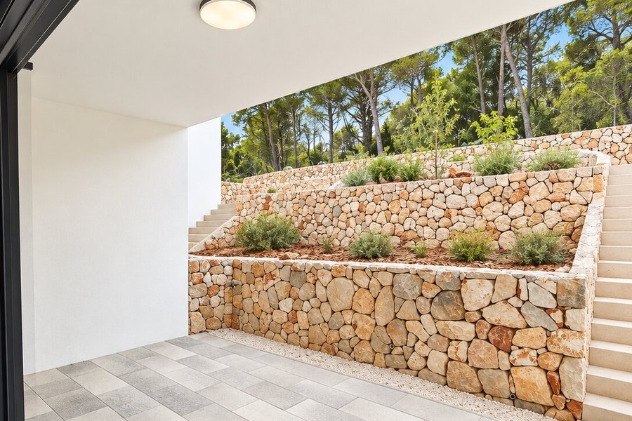 Terrasse vor den Natursteinmauern des Gartens