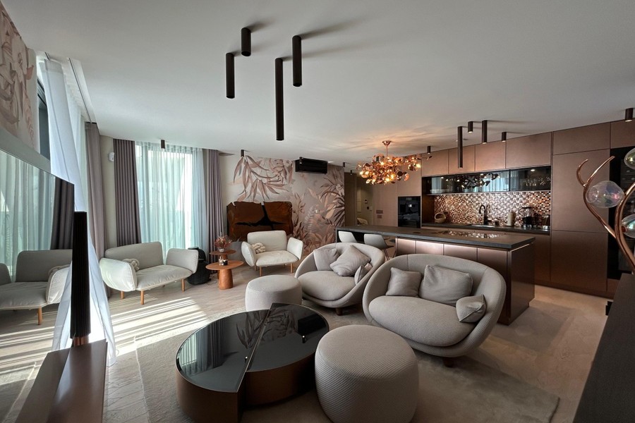 Wohnzimmer mit Sesseln und offener Küche