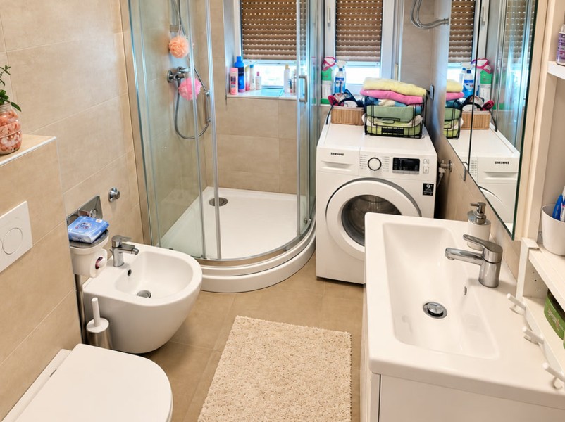 Badezimmer mit Dusche und Waschmaschine