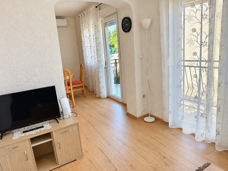 Wohnbereich mit Fernseher und Balkontür