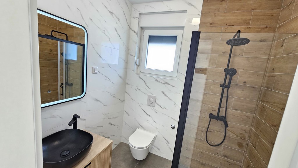 Badezimmer mit Regendusche und Spiegel