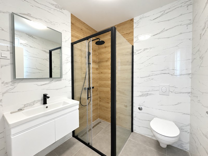 Badezimmer mit Regendusche und Holzoptik