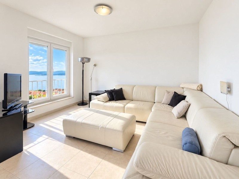 Wohnzimmer mit Ledersofa und Fenster zum Meer