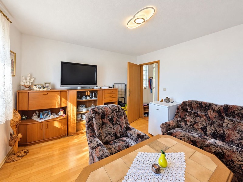 Wohnzimmer mit Fernseher und Holzboden
