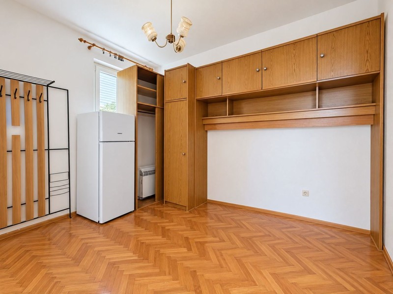Zimmer mit Holzschränken und Kühlschrank