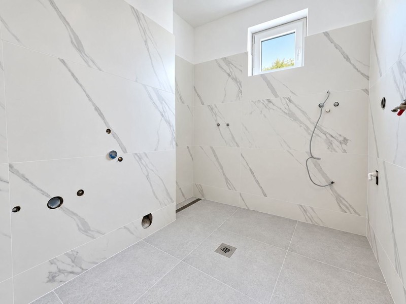 Badezimmer mit neuen Fliesen in Marmoroptik
