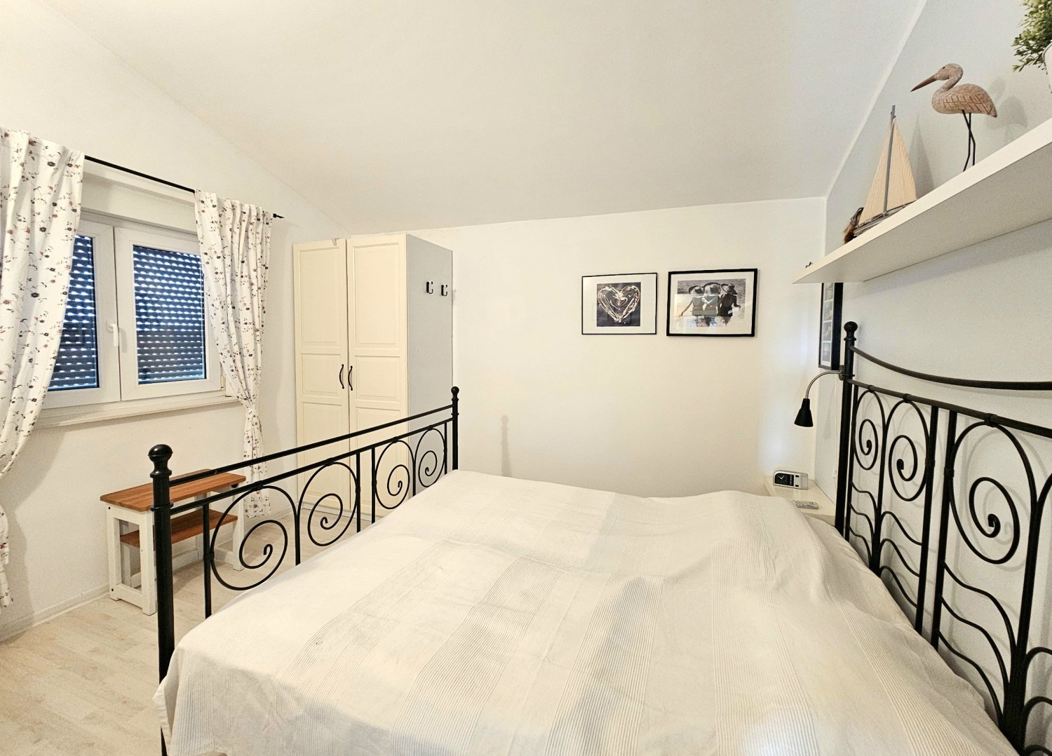 Schlafzimmer mit Doppelbett aus Metall unter der Dachschräge