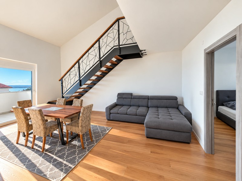 Wohnbereich mit Sofa und Treppe zur Galerie